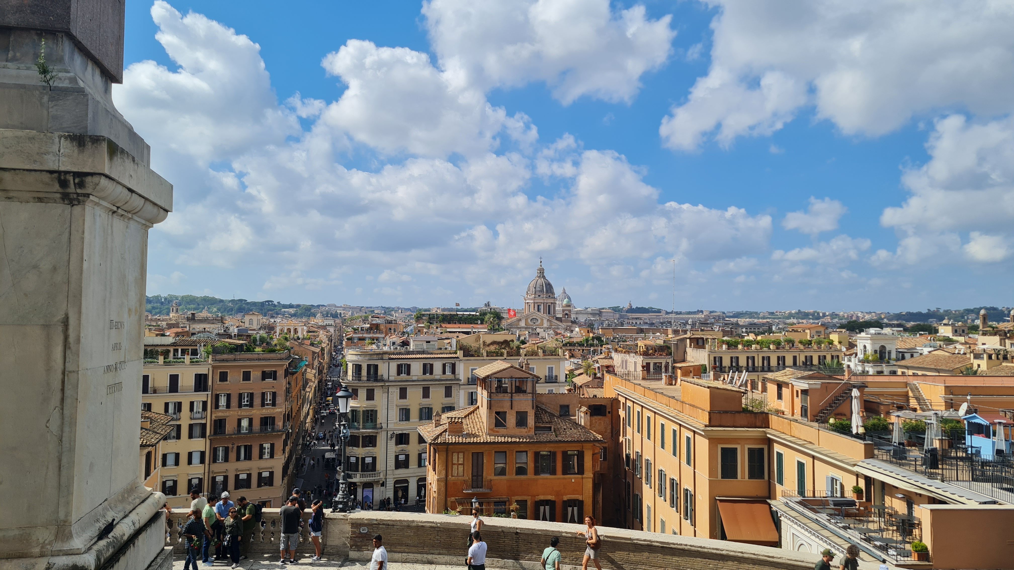 Rome's rooftops and a distant dome seen from the top of the Spanish Steps